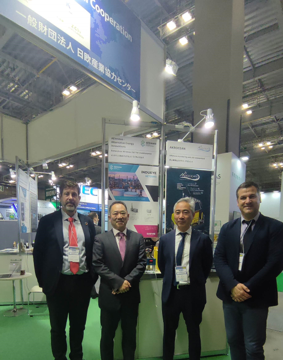 Three people in front of a trade fair booth